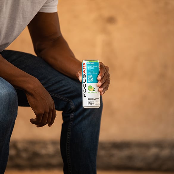 A man holding a can of FOCUSAID Melon Maté.