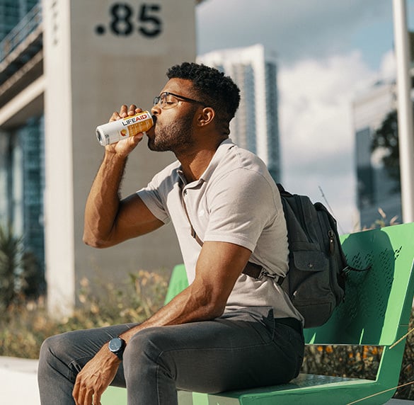 A man drinking a can of LIFEAID.