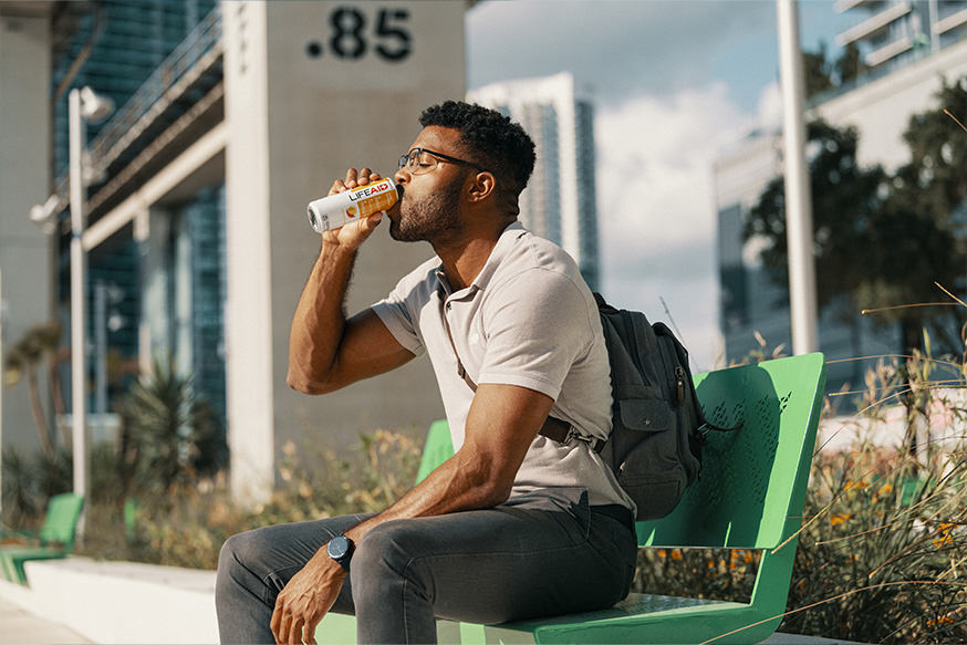 A man drinking a can of LIFEAID.