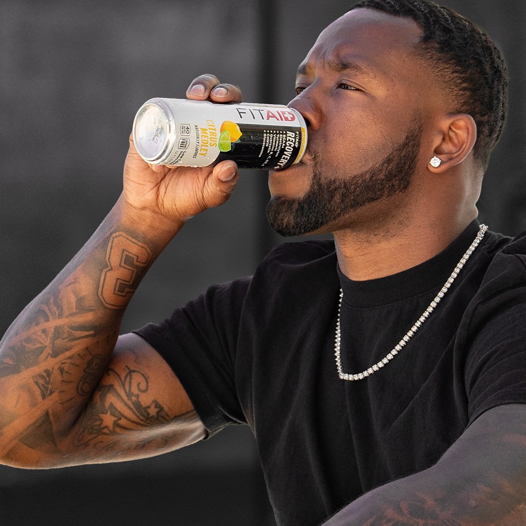 FITAID RECOVERY. A man drinking a can of fitaid energy drink