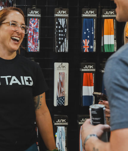 C ** ** JUK JUK. A woman is laughing in front of a display of junk socks