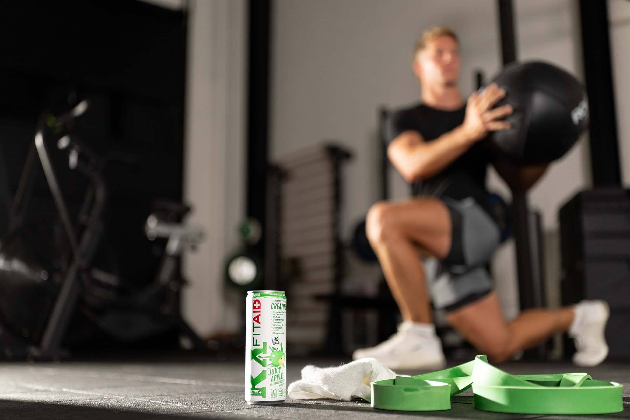 Athletic man doing a front squat accompanied by three FITAID RX.