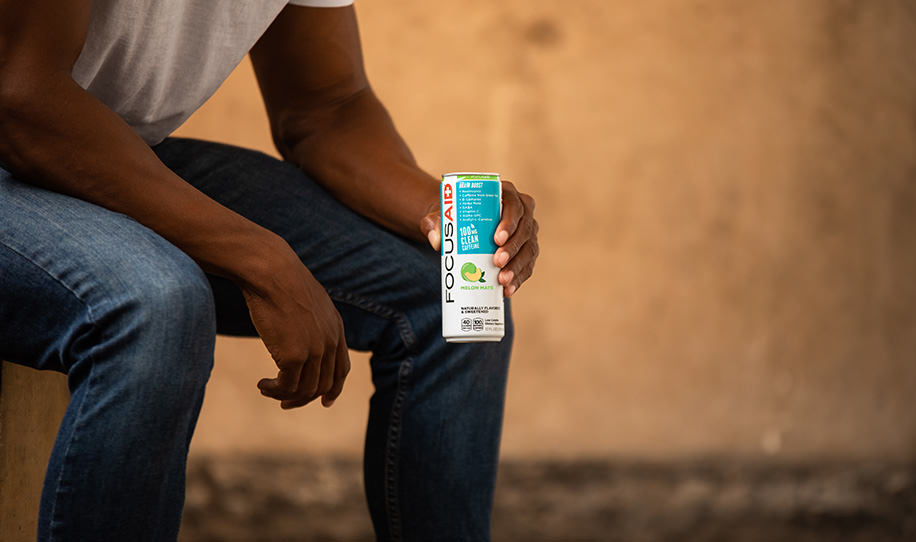 A man holding a can of FOCUSAID Melon Maté.